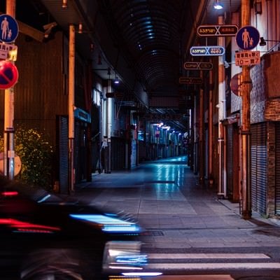 車の往来と深夜の直方市古町商店街の写真