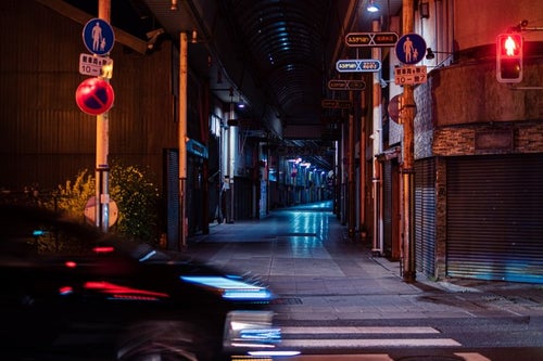 車の往来と深夜の直方市古町商店街の写真