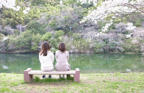 のおがた内ヶ磯ダムにあるベンチに座る女性ふたりの写真