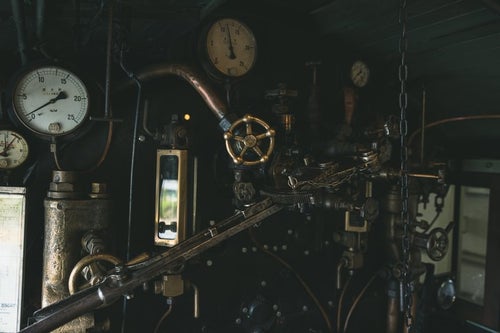 機関室内の圧力計とハンドルの写真