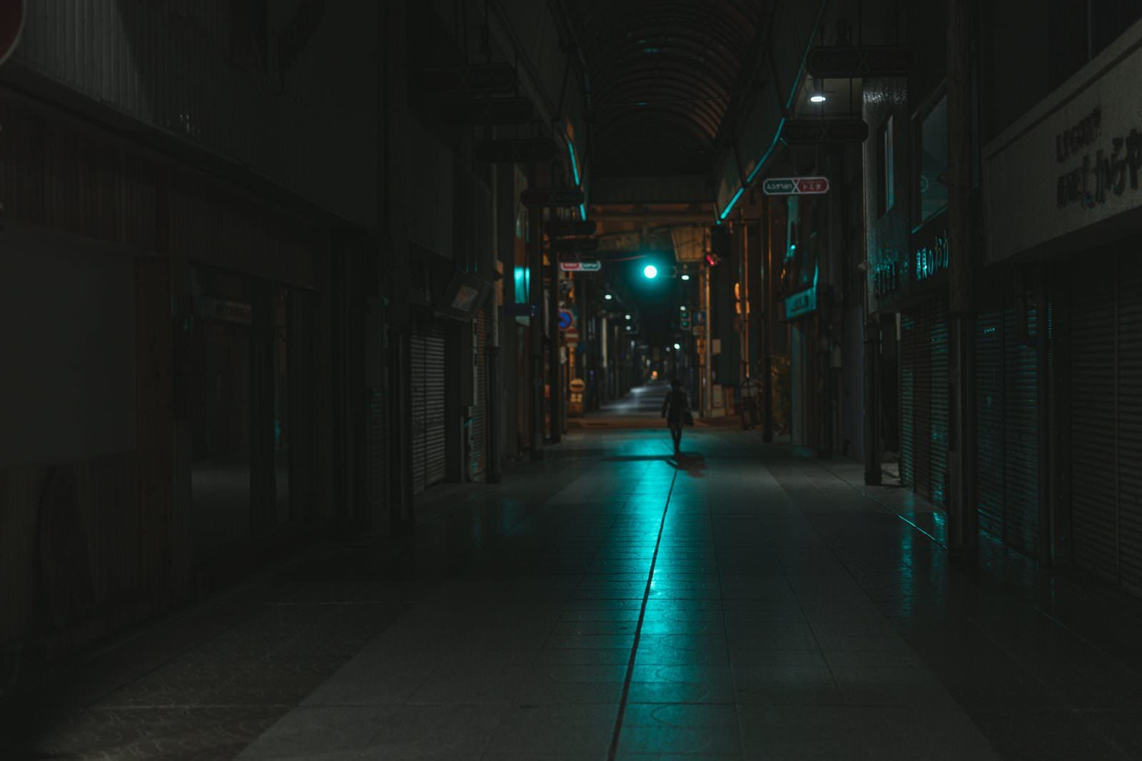 「青信号の光が伸びる深夜の直方市古町商店街」の写真
