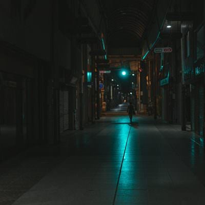 青信号の光が伸びる深夜の直方市古町商店街の写真