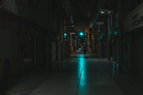 青信号の光が伸びる深夜の直方市古町商店街の写真
