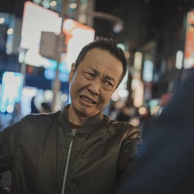 繁華街で激怒して歯を食いしばる男性と喧嘩トラブルの写真