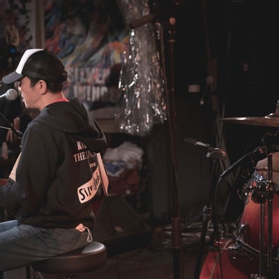ライブハウスで演奏するボーカルをステージ裏から撮影の写真