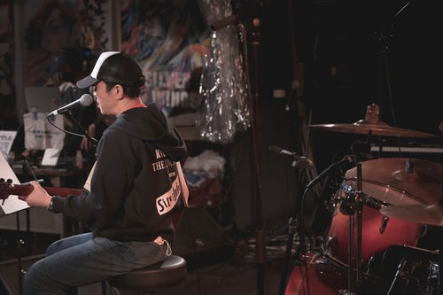 ライブハウスで演奏するボーカルをステージ裏から撮影の写真