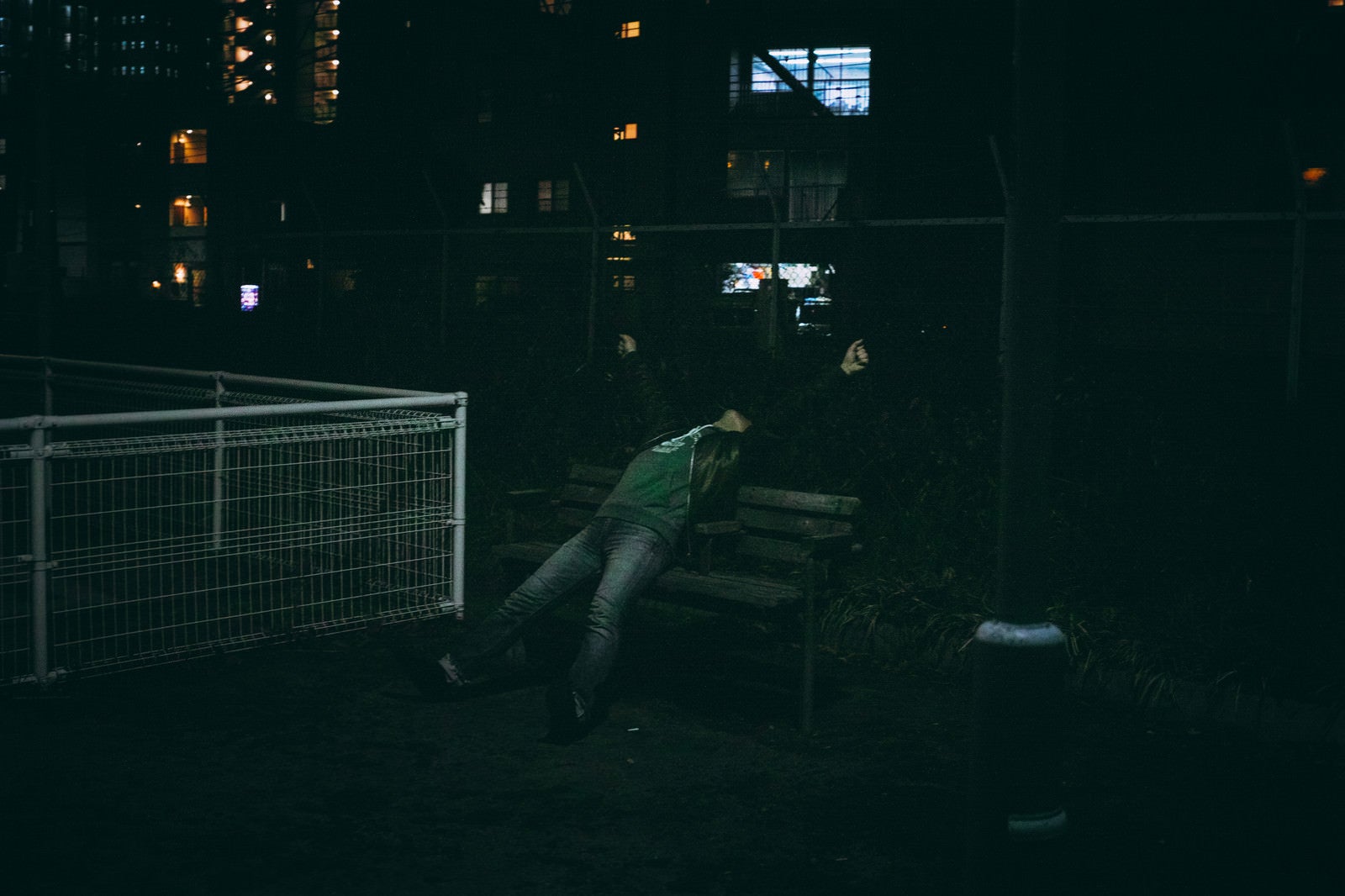 「誰もいない夜の公園ガッツポーズからの伸びをする男性」の写真［モデル：のせさん］