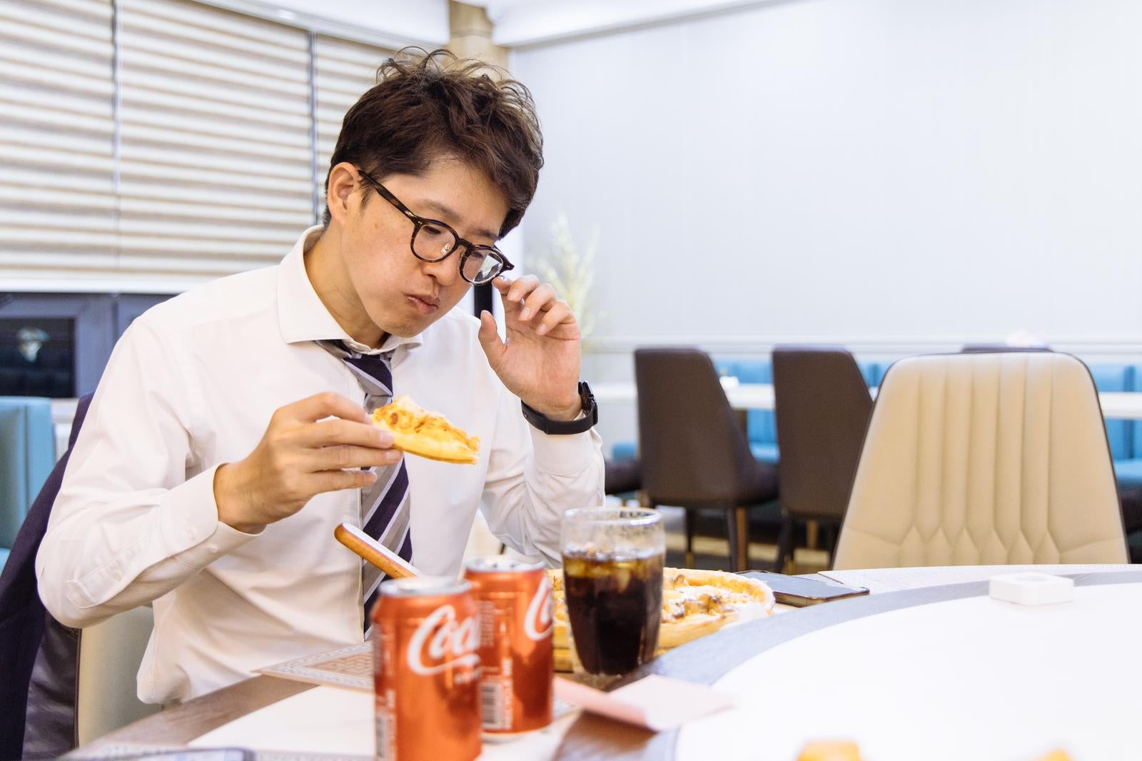 「忙しいビジネスマンの夜食タイム」の写真［モデル：野崎繁裕］