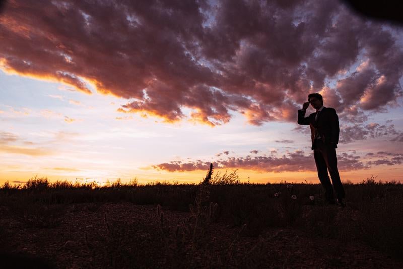 モンゴルの大地と夕焼けに染まるビジネスマンのシルエットの写真