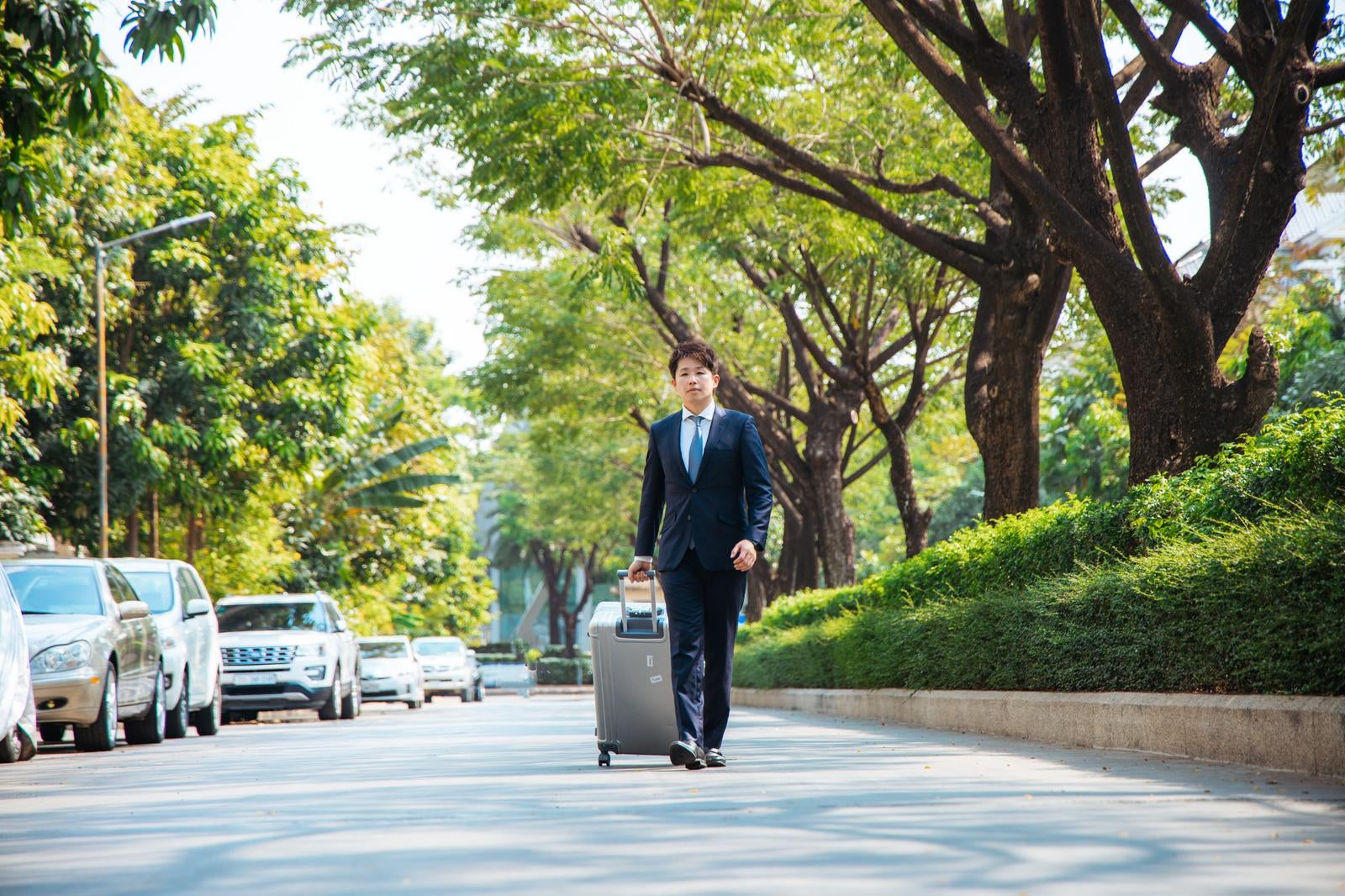 「スーツケースを片手に出張中のビジネスマン」の写真［モデル：野崎繁裕］