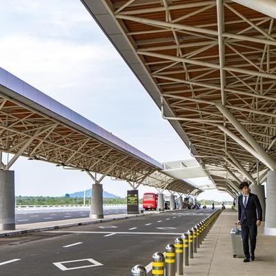 出張帰りの男性が空港ターミナルを歩くの写真