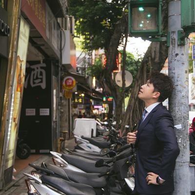 電柱に寄り掛かり上を見上げるM&Aアドバイザーの写真