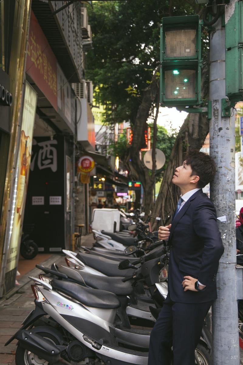 電柱に寄り掛かり上を見上げるM&Aアドバイザーの写真