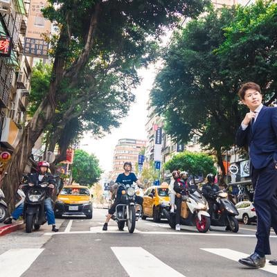 台湾市街をスーツで歩くビジネスマンの写真