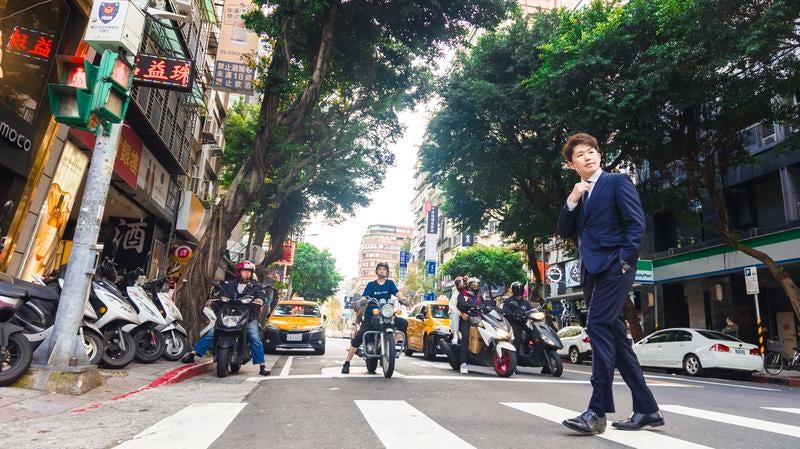 台湾市街をスーツで歩くビジネスマンの写真
