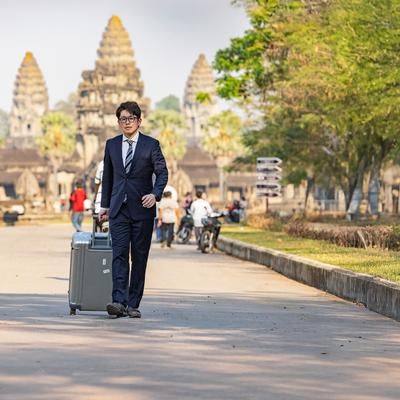 アンコールワットから渡航先へ出向くビジネスマンの写真