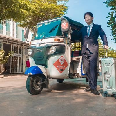 トゥクトゥクで出社するスーツ姿の男性の素材