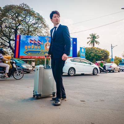 スーツ姿で異国を歩くM&Aアドバイザーの素材