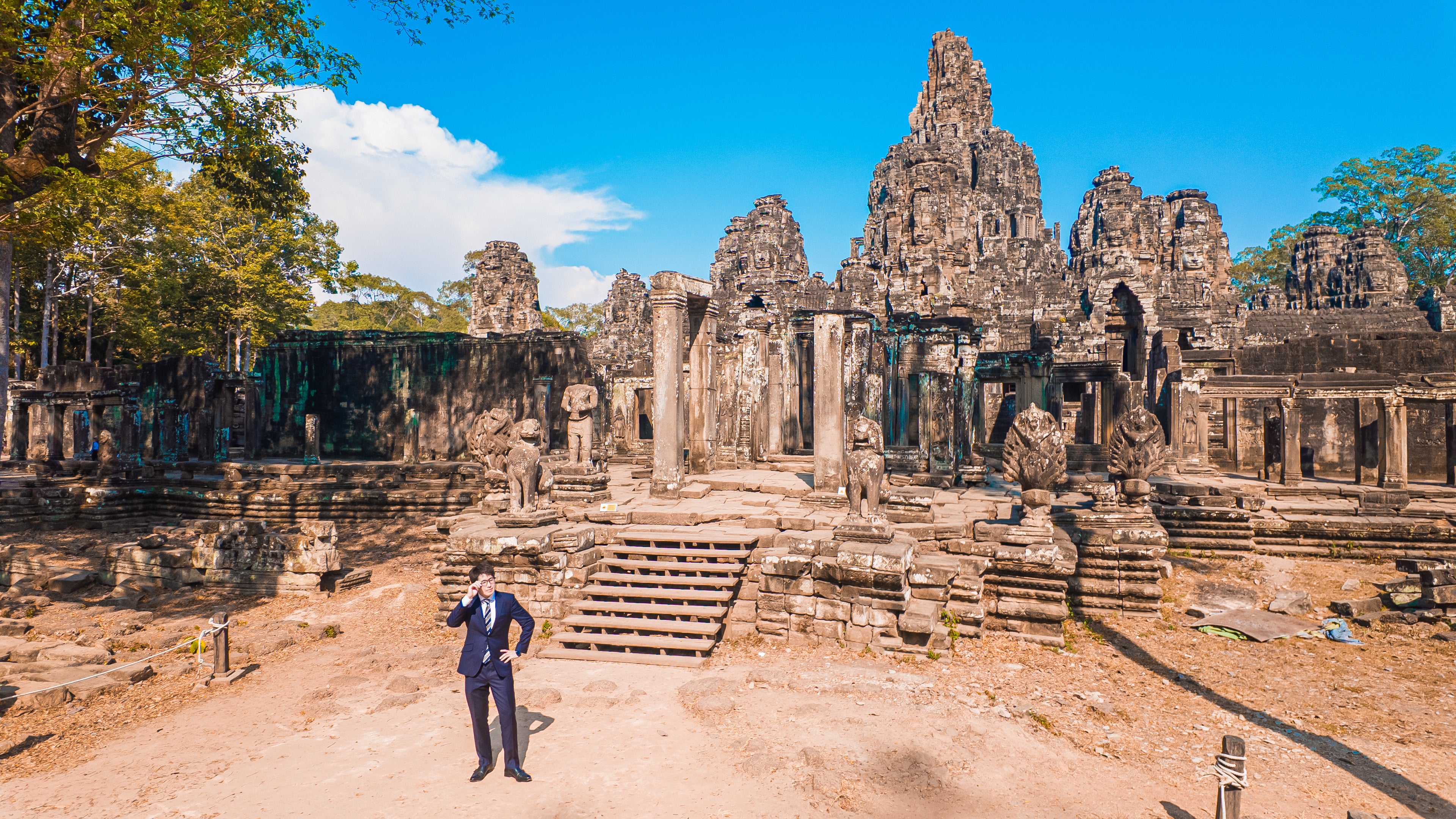 世界遺産（バイヨン）の遺跡を歩くスー姿のM&Aアドバイザーの無料の