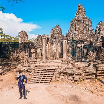 世界遺産（バイヨン）の遺跡を歩くスー姿のM&Aアドバイザーの写真