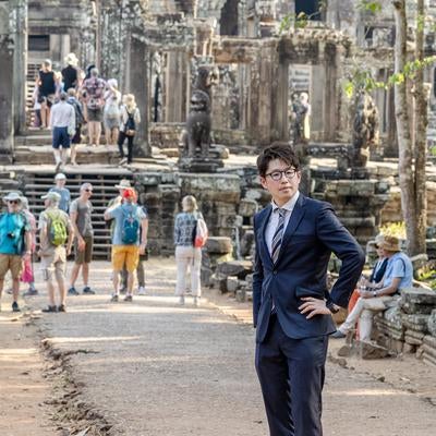 世界遺産を視察するスーツ姿の男性の写真