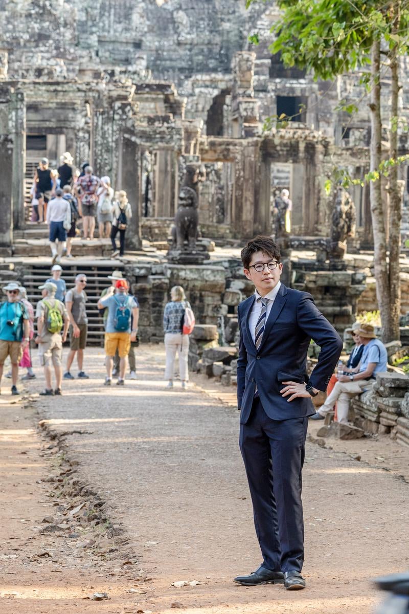 世界遺産を視察するスーツ姿の男性の写真