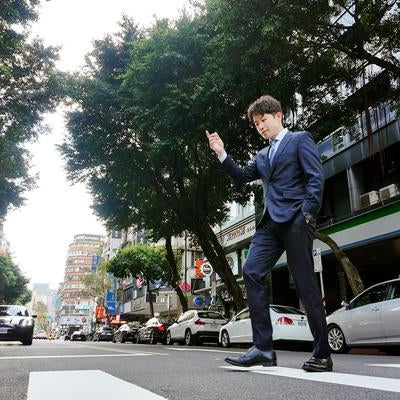 軽やかに横断するビジネスマンの写真