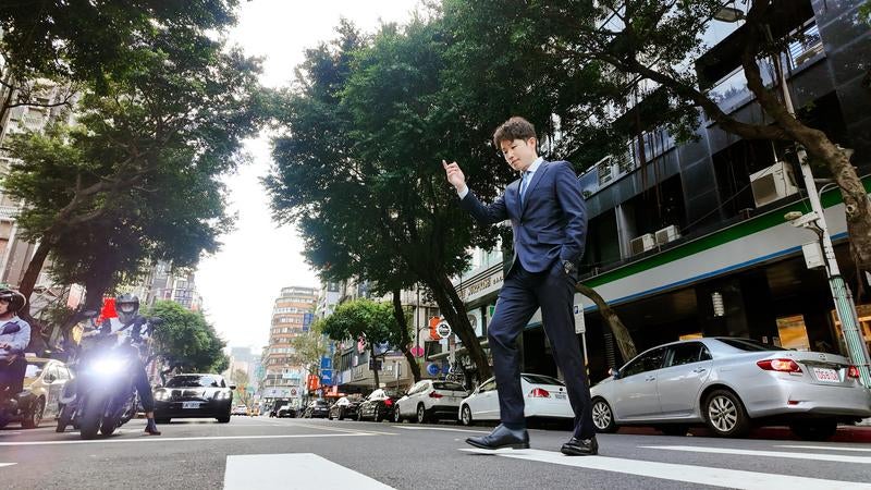 軽やかに横断するビジネスマンの写真
