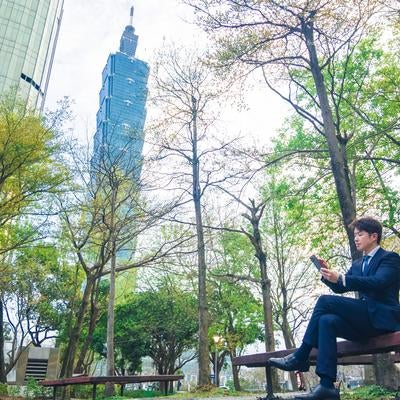 高層ビル「台北101（Taipei 101）」とくつろぐビジネスマンの写真