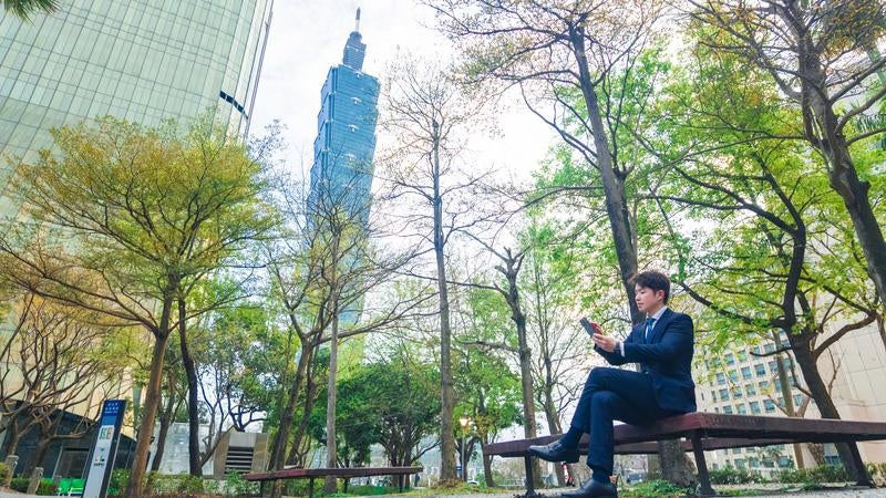 高層ビル「台北101（Taipei 101）」とくつろぐビジネスマンの写真