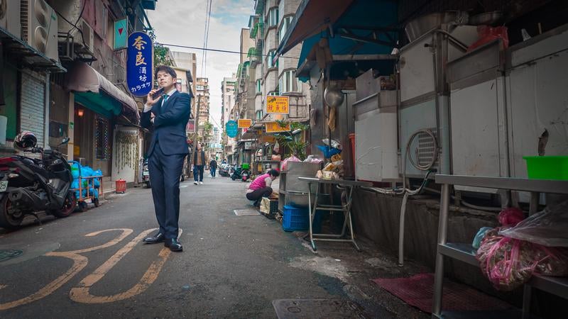 台北の街並みを視察するスーツ姿のM&Aアドバイザーの写真