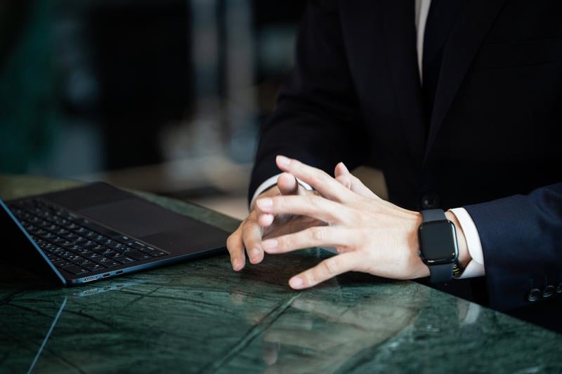 デスクで手を組み考えるコンサルタントの写真