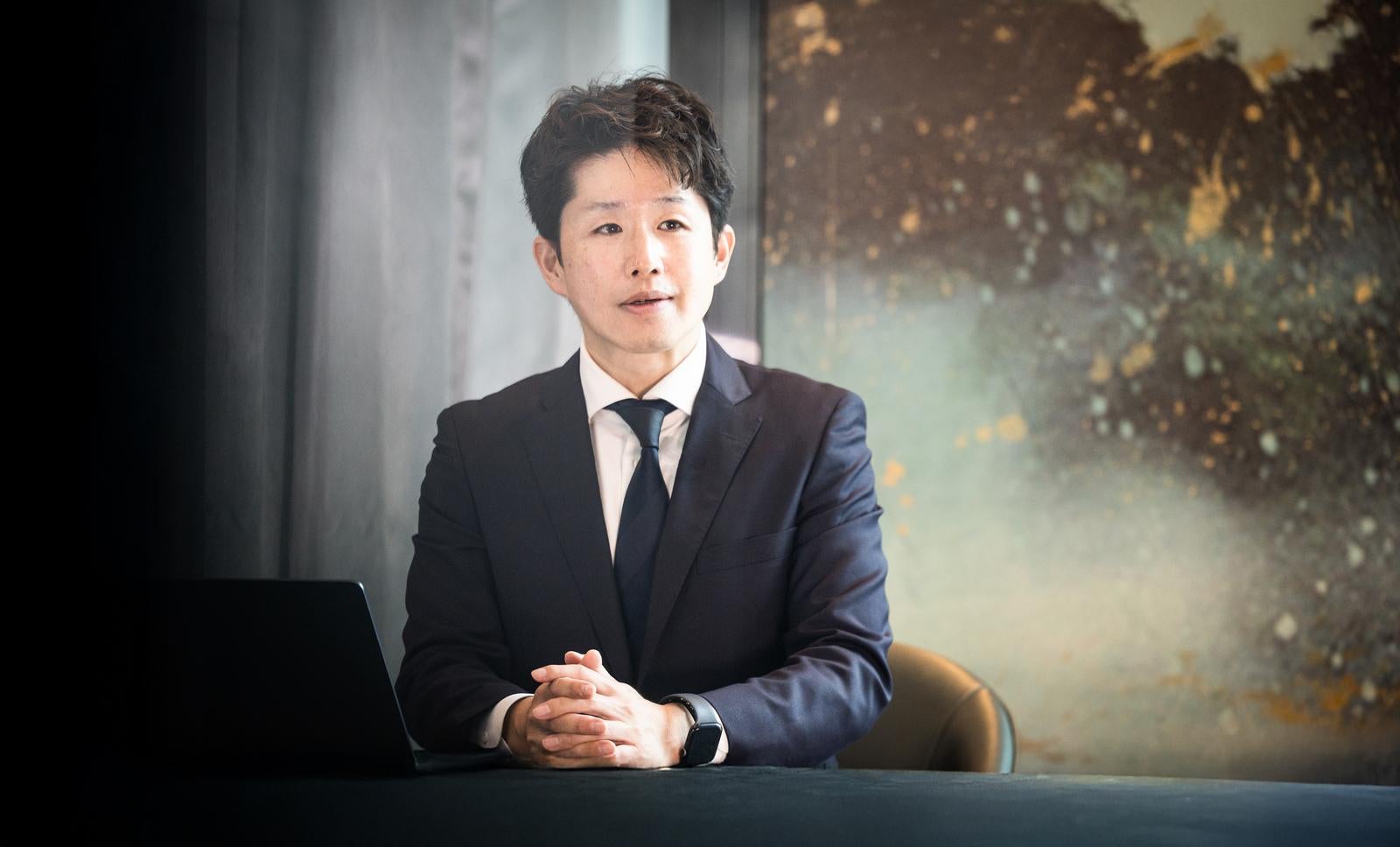 「落ち着いた雰囲気の会議室でクライアントと面談するM&Aコンサルタント」の写真［モデル：野崎繁裕］