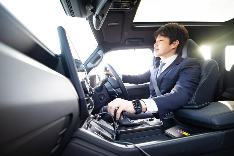 スーツ姿で車を運転するビジネスマン