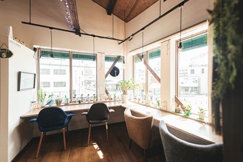 陽の光が入るカフェの窓辺席の写真
