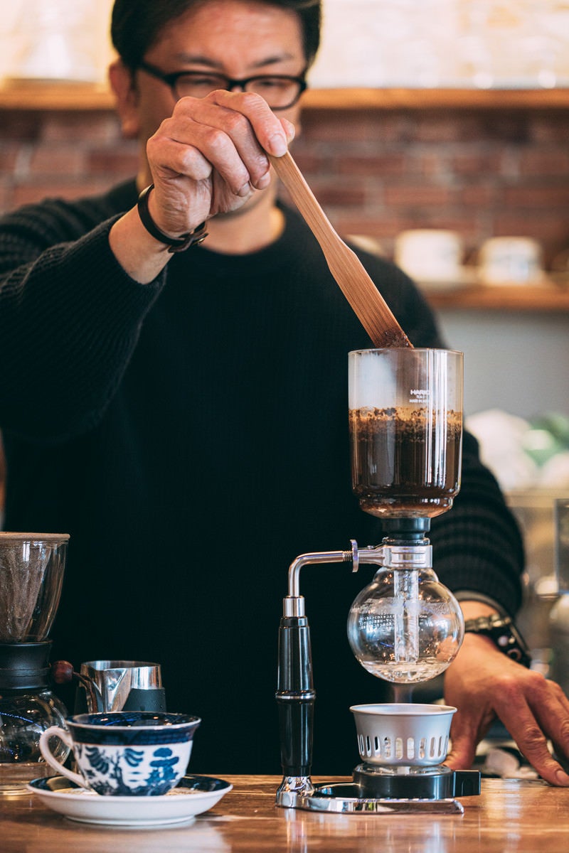 「カフェのマスターがコーヒーを抽出中」の写真