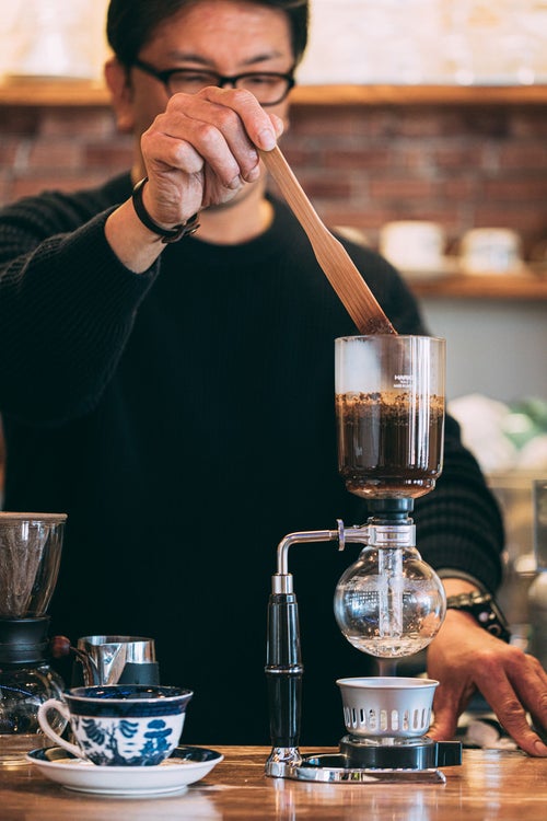カフェのマスターがコーヒーを抽出中の写真