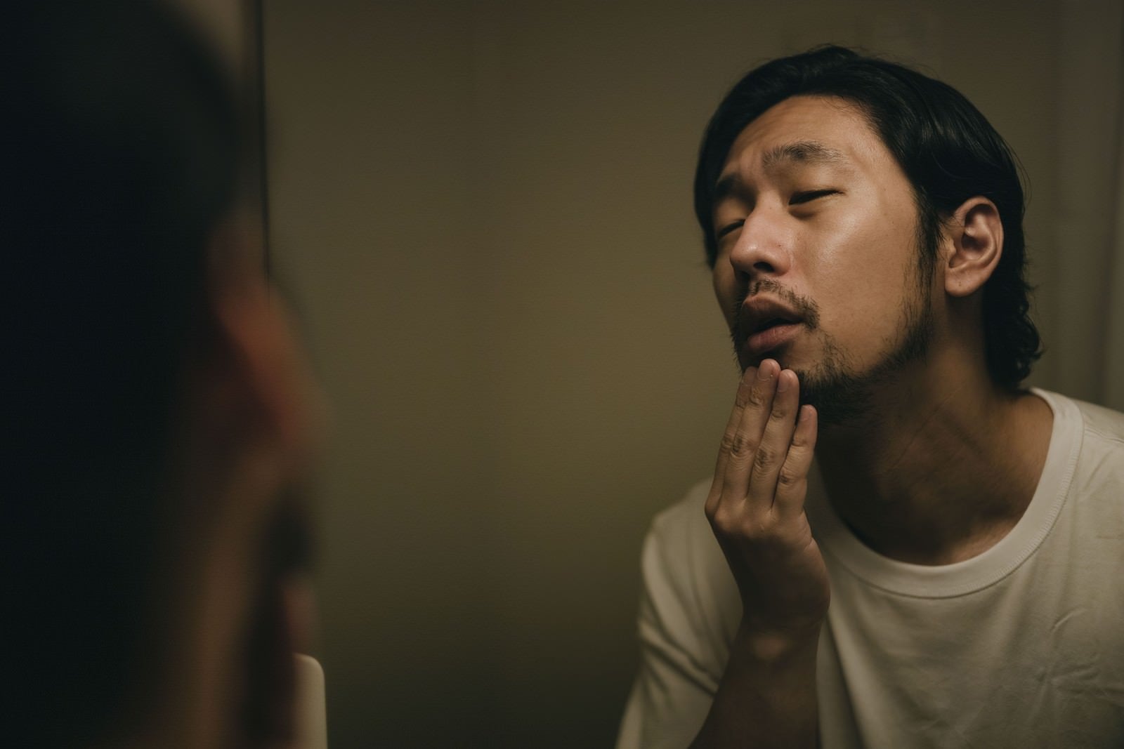 「鏡に映るしかめっ面の髭男子」の写真［モデル：大川竜弥］