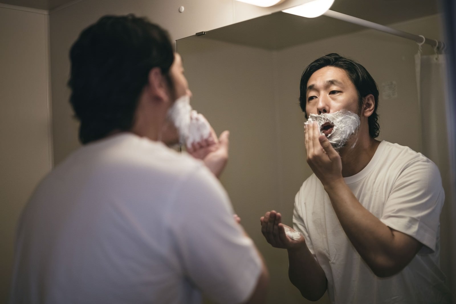 「鼻下にシェービング剤を塗り込む男性」の写真［モデル：大川竜弥］