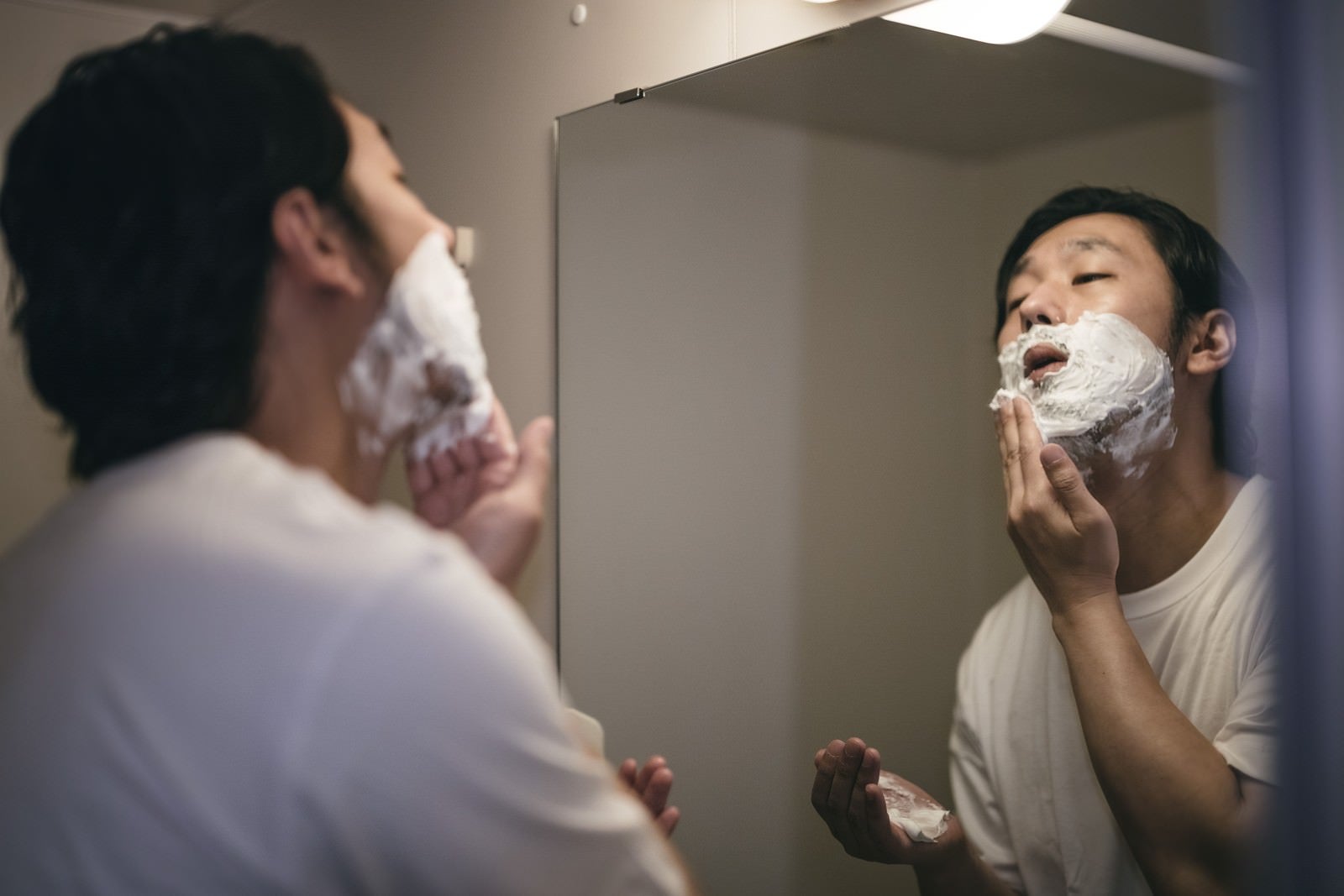 「髭剃り用の泡を顔に塗る男性」の写真［モデル：大川竜弥］