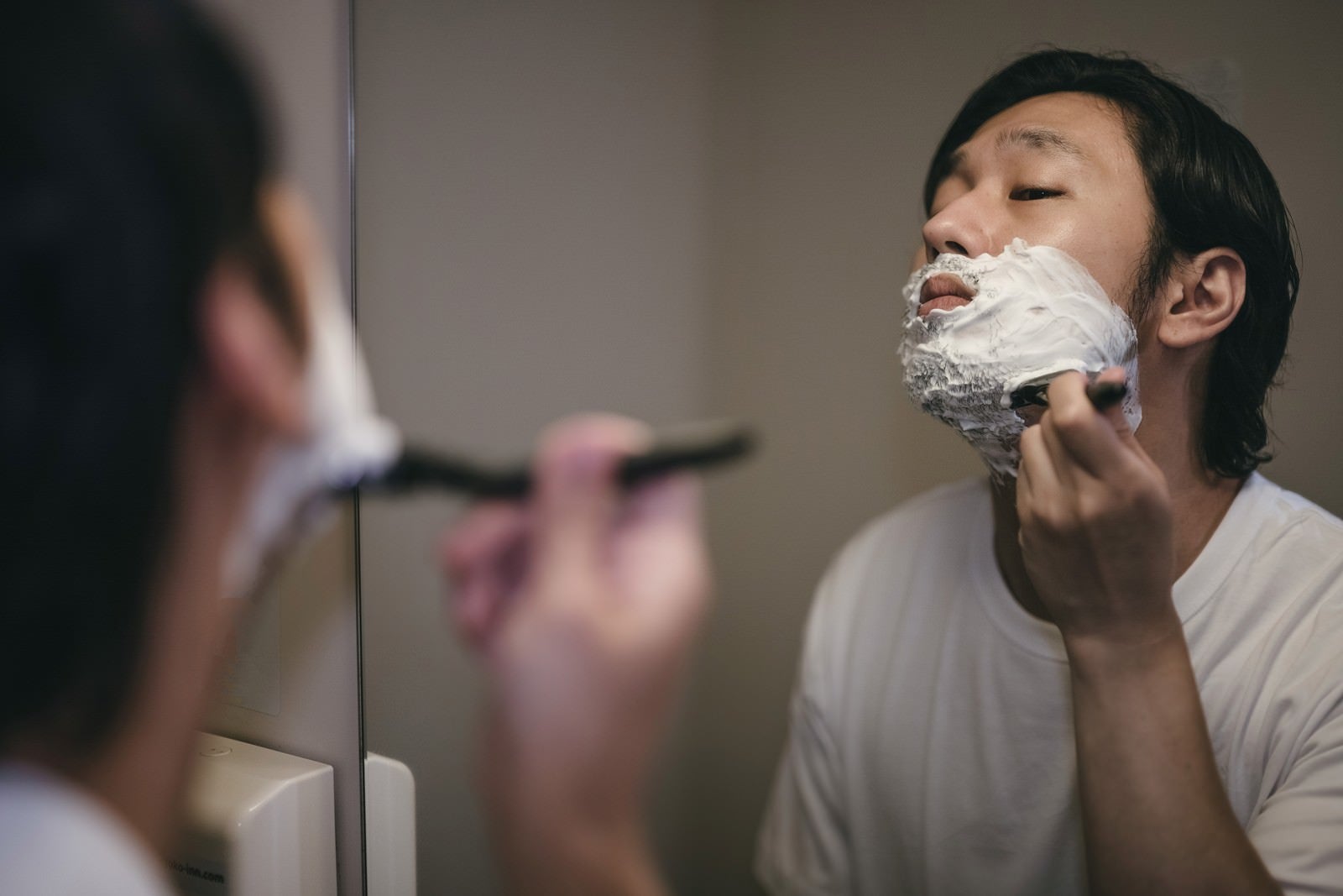 「顎下を剃り上げる男性」の写真［モデル：大川竜弥］