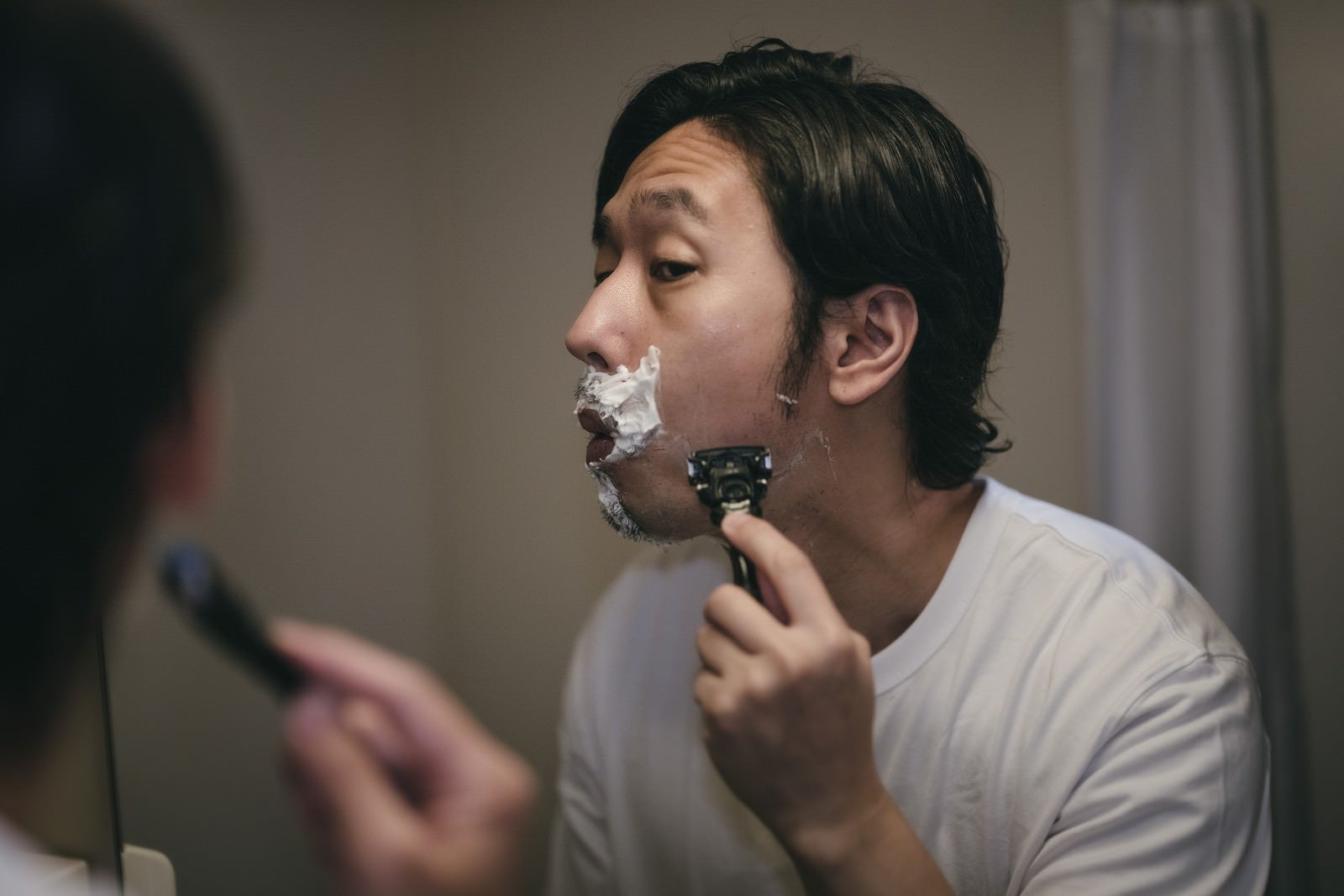 「カミソリで髭剃りをする男性」の写真［モデル：大川竜弥］