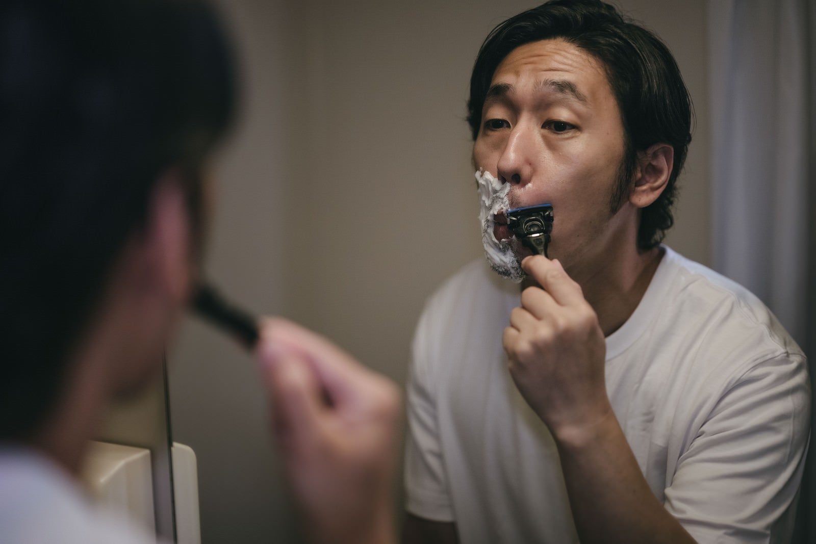 「頬から鼻下を剃る男性」の写真［モデル：大川竜弥］