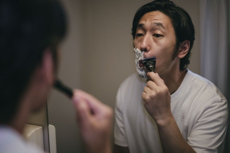 頬から鼻下を剃る男性の写真