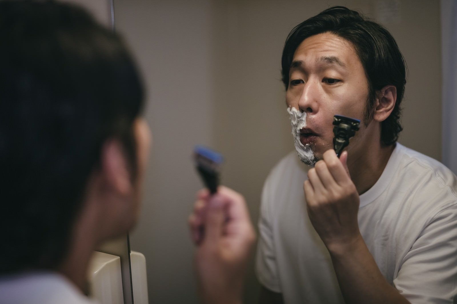 「泡がない部分を深剃りする男性」の写真［モデル：大川竜弥］