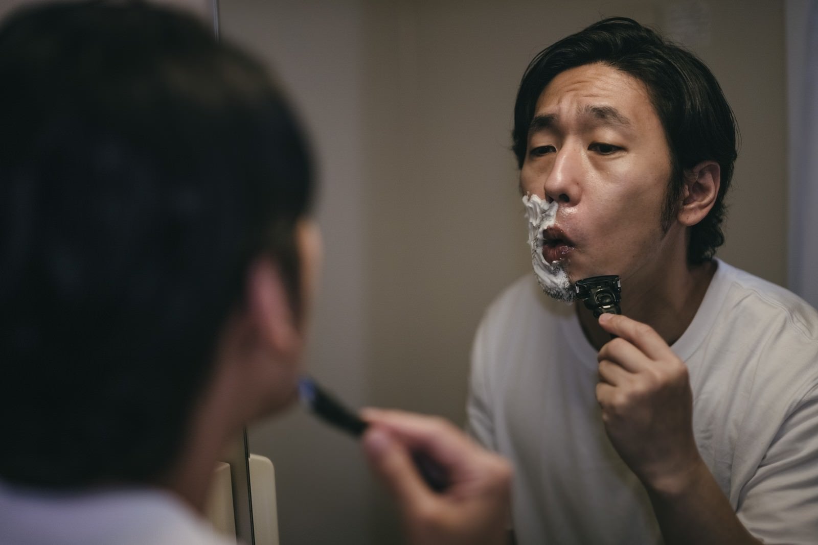 「顎のラインを丁寧に深剃りする男性」の写真［モデル：大川竜弥］