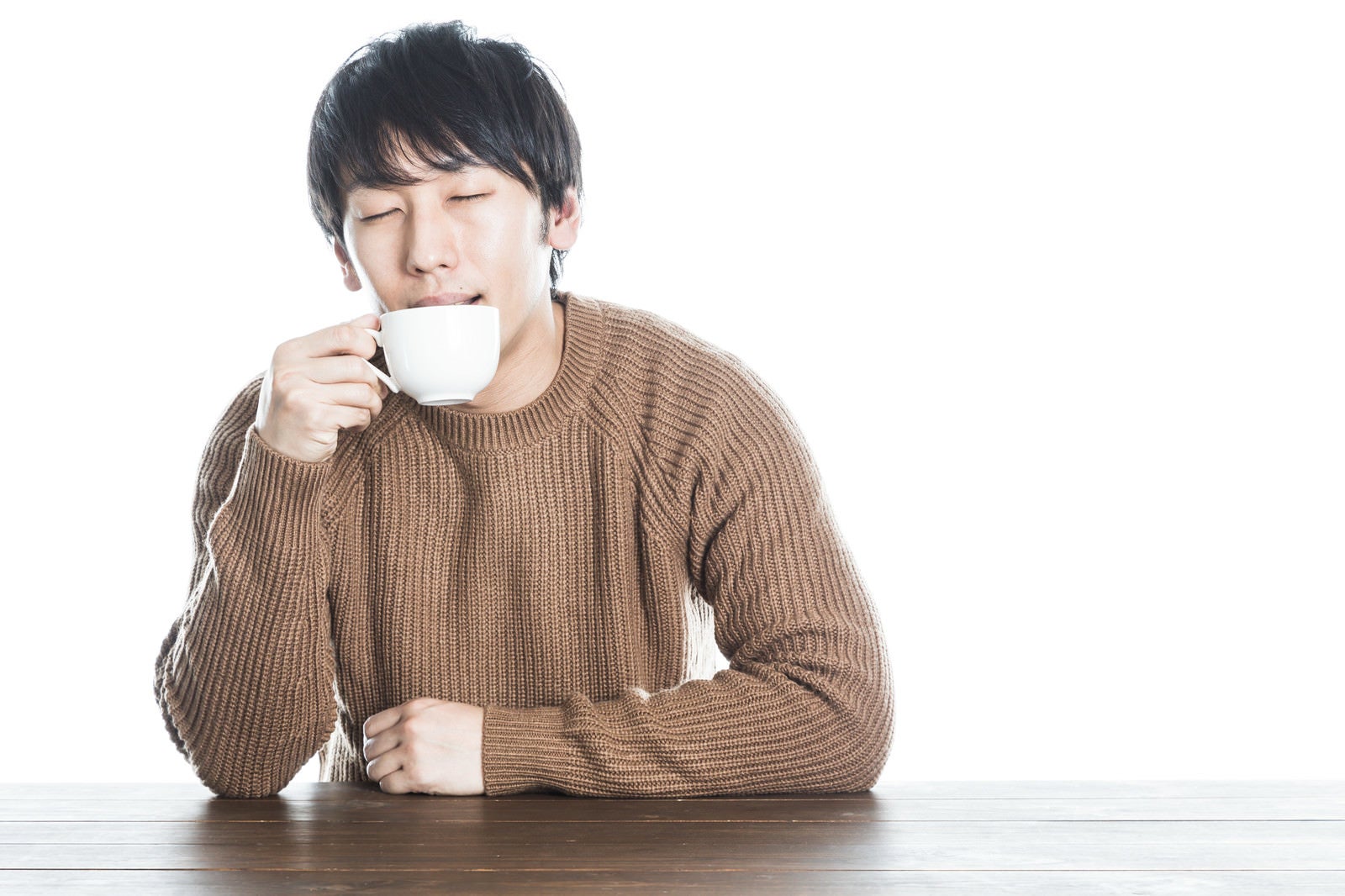「温かい紅茶を飲んで幸せそうな男性」の写真［モデル：大川竜弥］