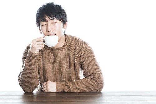 温かい紅茶を飲んで幸せそうな男性の写真