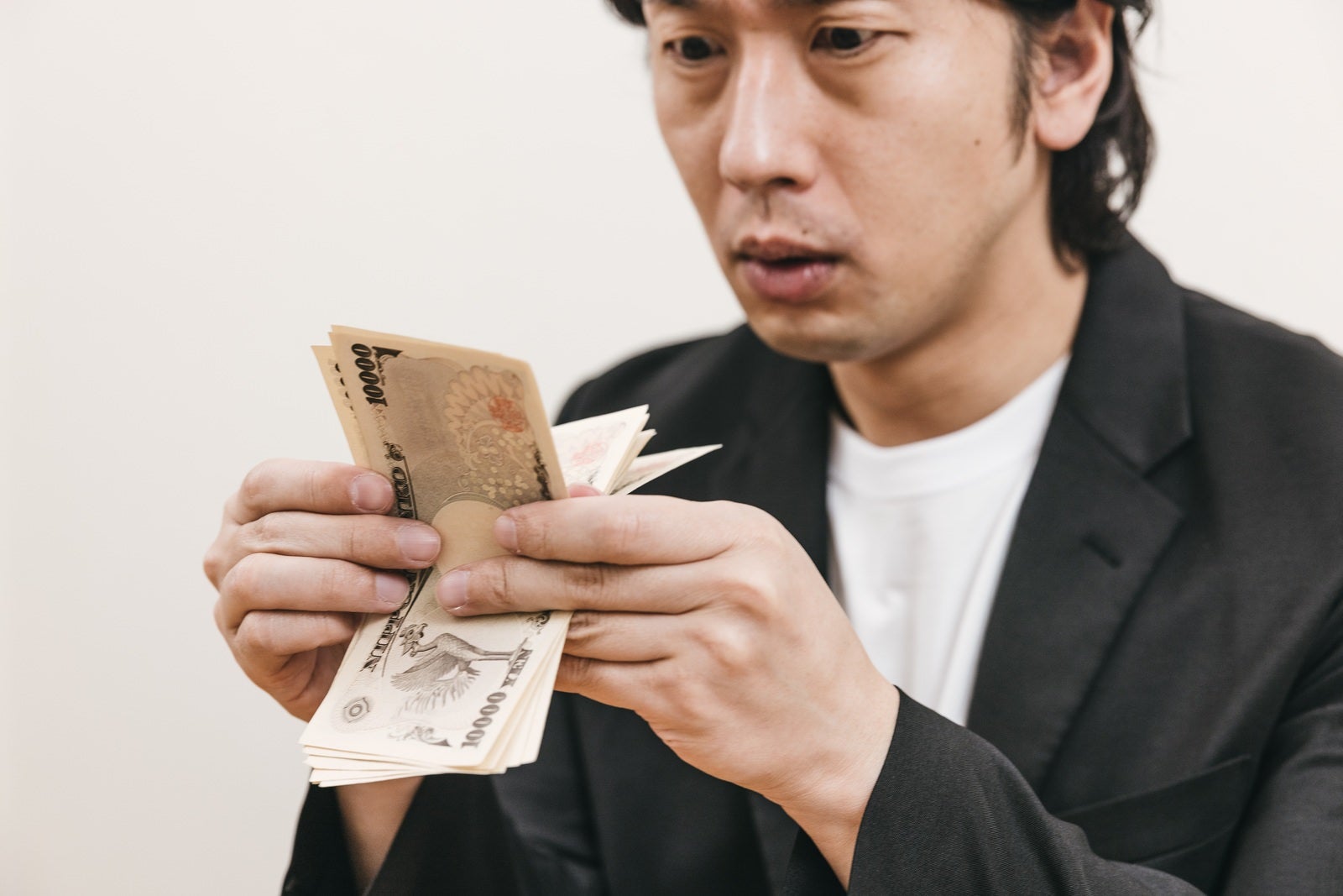 「必死に紙幣を札勘する男性」の写真［モデル：大川竜弥］