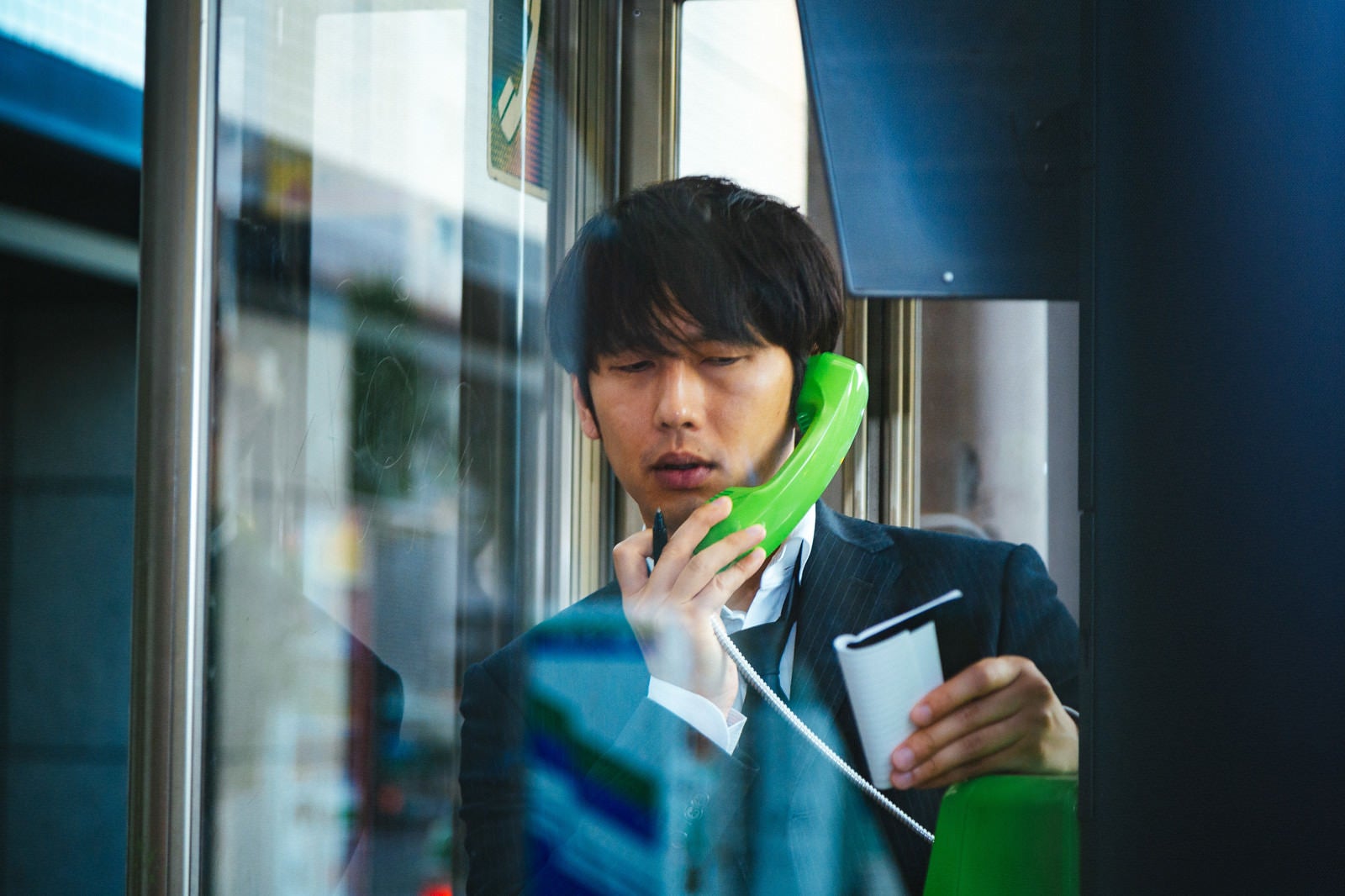 「スマートフォンを忘れ電話ボックスに駆け込んだ男性」の写真［モデル：大川竜弥］